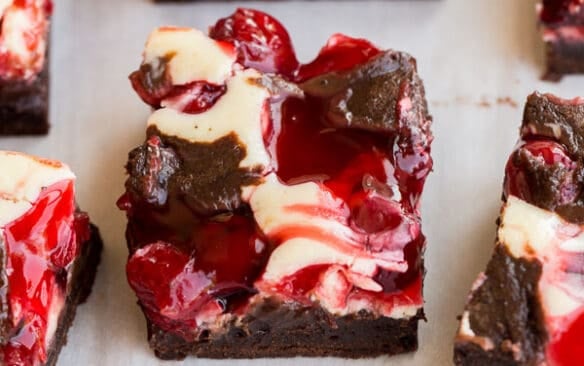 close up image of cherry cheesecake brownie on parchment