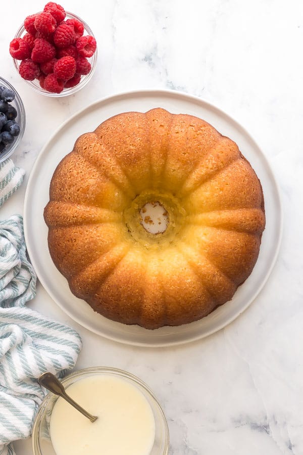 This Greek Yogurt Lemon Bundt Cake is so moist and packed with lemon flavor! It's made healthier with greek yogurt and is perfect topped with whipped cream and fresh berries. #lemon #cake #dessert overhead image of plain lemon bundt cake