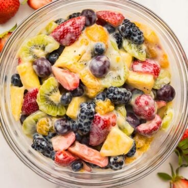 overhead image of creamy fruit salad in glass bowl
