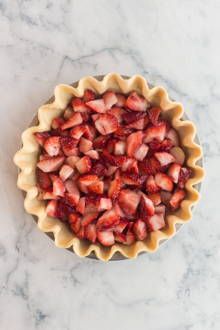 uncooked pie crust filled with fresh strawberries