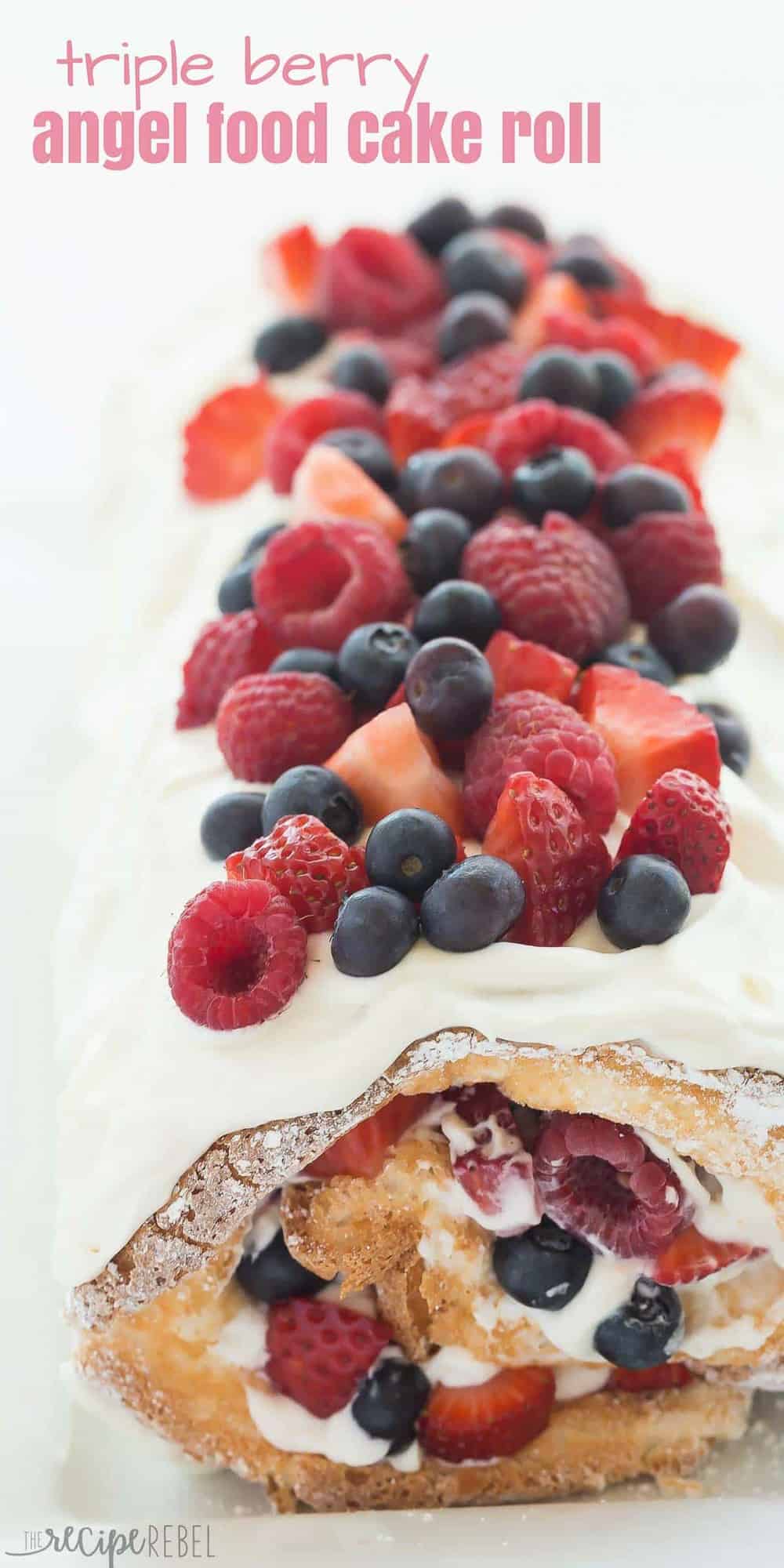 long image of triple berry angel food cake roll with lots of berries on top and pink title