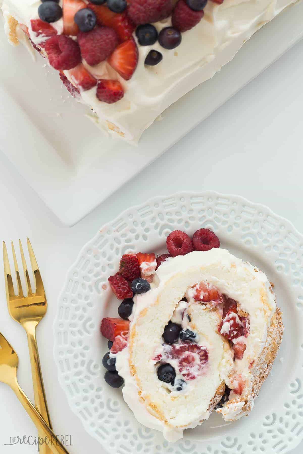 slice of angel food cake roll on white plate and whole cake on the side