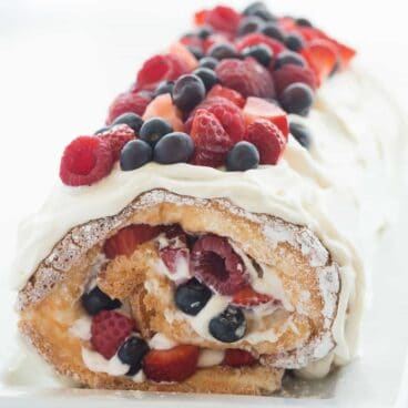 This Triple Berry Angel Food Cake Roll is an easy red, white and blue dessert (or just red and white!) for the 4th of July or Canada Day, or any day! Perfect with fresh summer strawberries, raspberries and blueberries :) Includes step by step recipe video. | 4th of july | july 4 | Canada Day | summer dessert | fresh fruit | easy dessert | cake mix