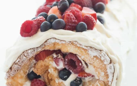 This Triple Berry Angel Food Cake Roll is an easy red, white and blue dessert (or just red and white!) for the 4th of July or Canada Day, or any day! Perfect with fresh summer strawberries, raspberries and blueberries :) Includes step by step recipe video. | 4th of july | july 4 | Canada Day | summer dessert | fresh fruit | easy dessert | cake mix