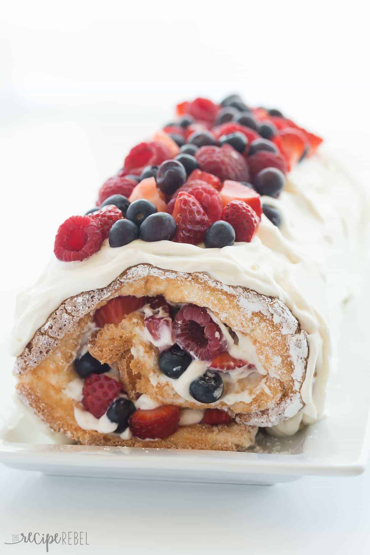 This Triple Berry Angel Food Cake Roll is an easy red, white and blue dessert (or just red and white!) for the 4th of July or Canada Day, or any day! Perfect with fresh summer strawberries, raspberries and blueberries :) Includes step by step recipe video. | 4th of july | july 4 | Canada Day | summer dessert | fresh fruit | easy dessert | cake mix