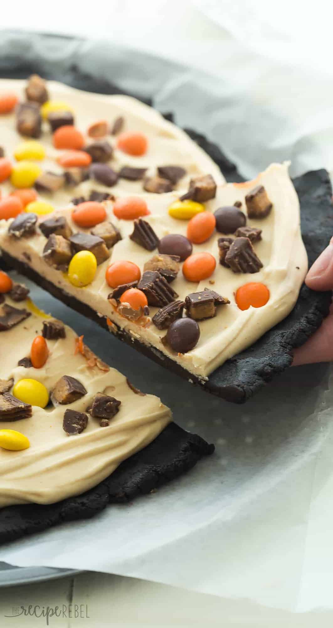 long image of peanut butter cup frozen dessert pizza with hand pulling out a piece