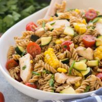 This BBQ Chicken Pasta Salad is loaded with fresh summer vegetables and chicken and tossed in a light dressing with a hint of barbecue flavor for an easy, meal in one perfect for picnics! Step by step recipe video. | summer salad | picnic salad | cold salad | summer veggies | healthy recipe