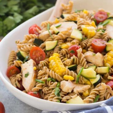 This BBQ Chicken Pasta Salad is loaded with fresh summer vegetables and chicken and tossed in a light dressing with a hint of barbecue flavor for an easy, meal in one perfect for picnics! Step by step recipe video. | summer salad | picnic salad | cold salad | summer veggies | healthy recipe