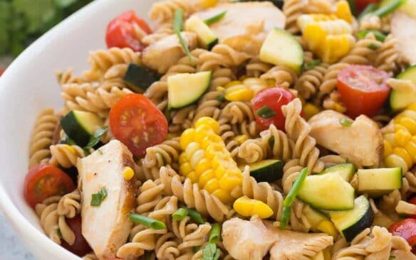 This BBQ Chicken Pasta Salad is loaded with fresh summer vegetables and chicken and tossed in a light dressing with a hint of barbecue flavor for an easy, meal in one perfect for picnics! Step by step recipe video. | summer salad | picnic salad | cold salad | summer veggies | healthy recipe