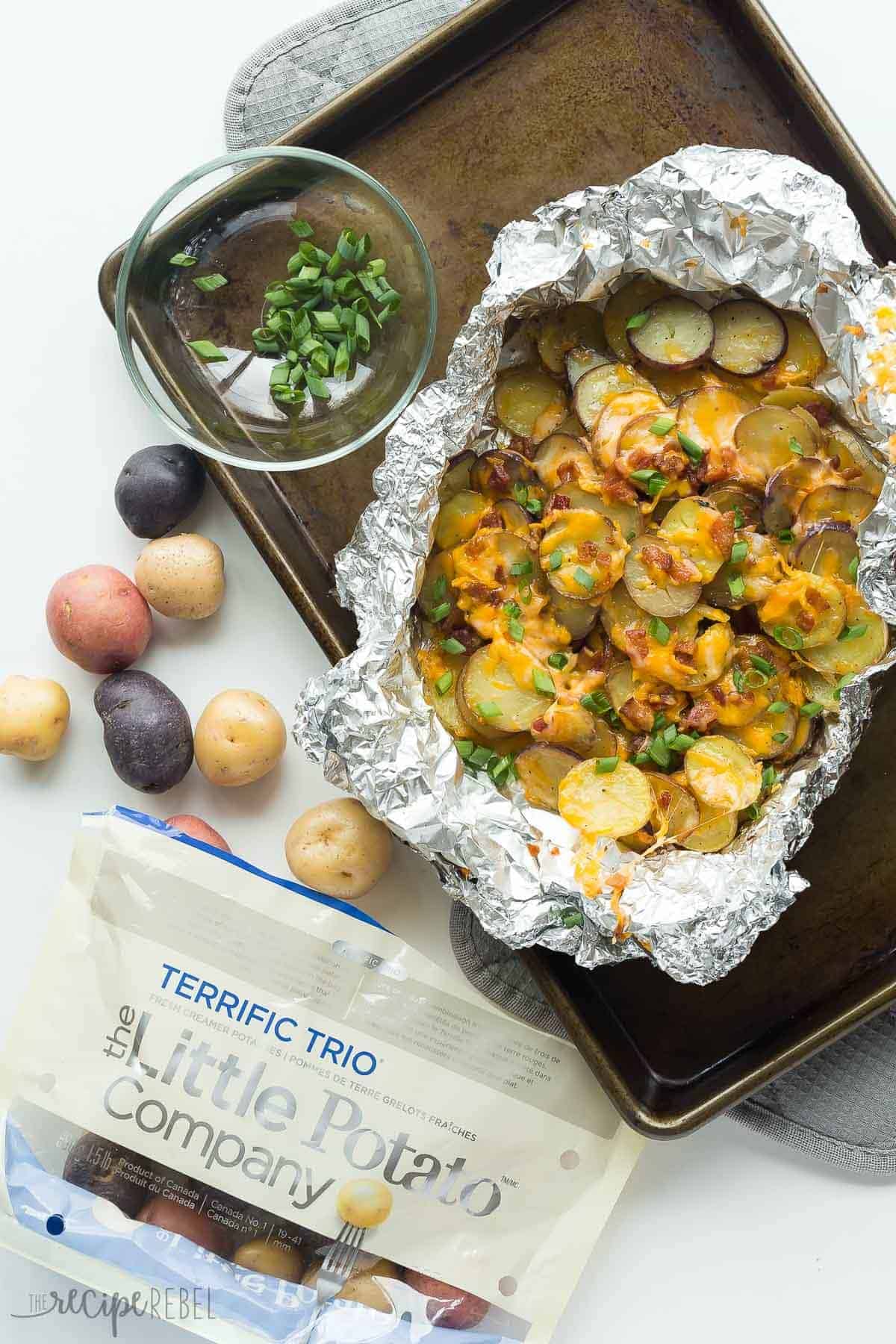 cheesy grilled potatoes overhead in foil pack with open bag of little potatoes on the side