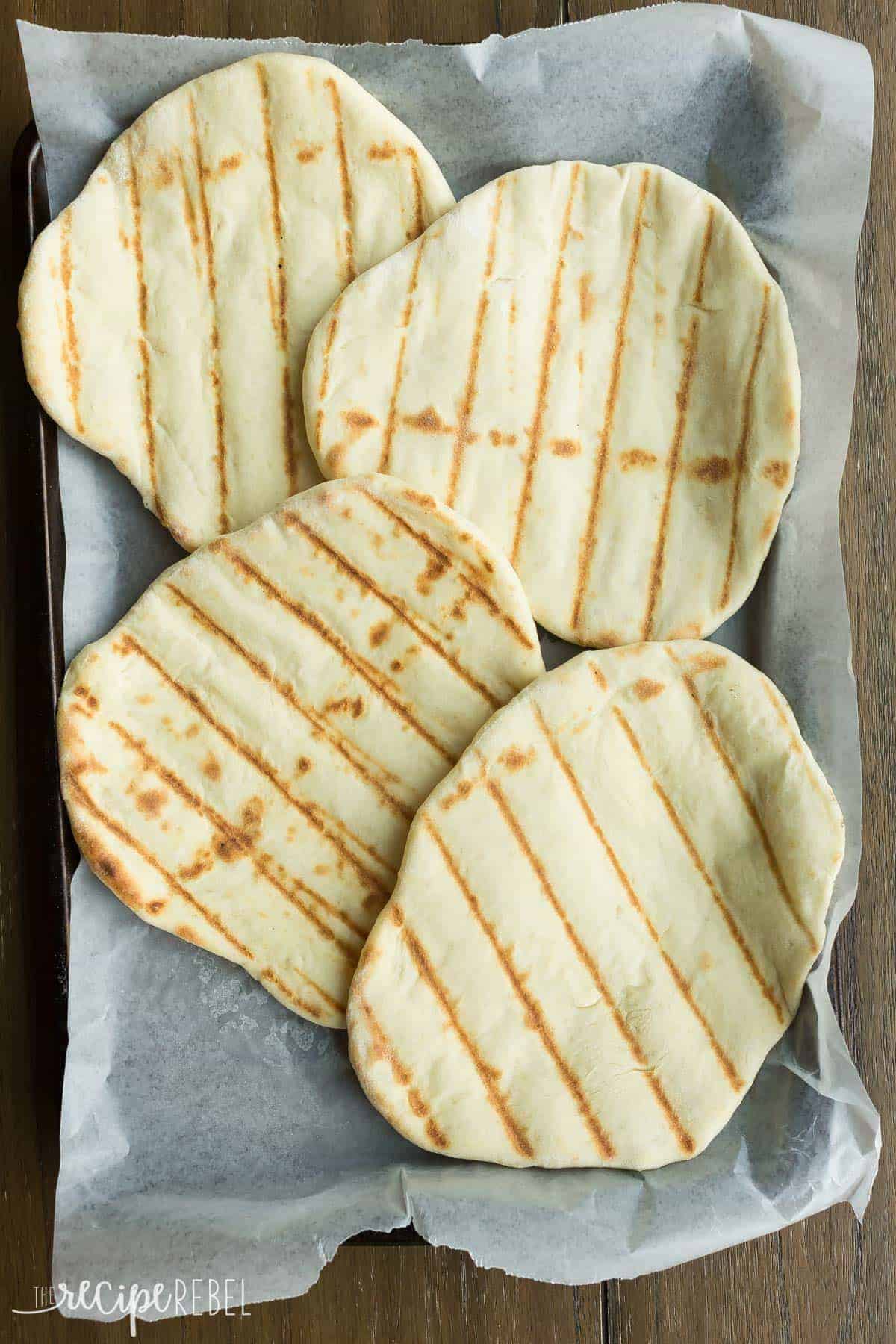 grilled pizza dough on a baking sheet ready for toppings