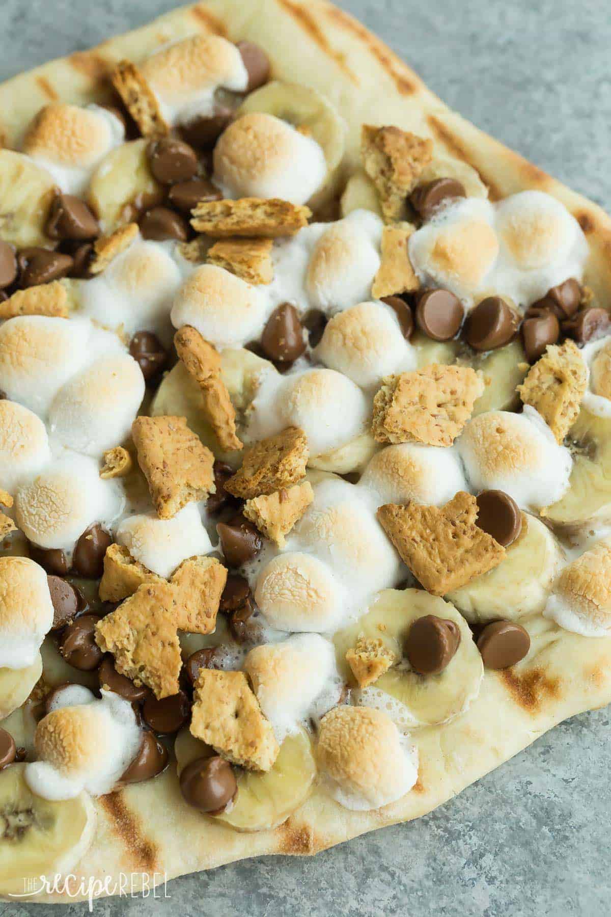 grilled smores dessert pizza with mini marshmallows chocolate chips and graham crackers