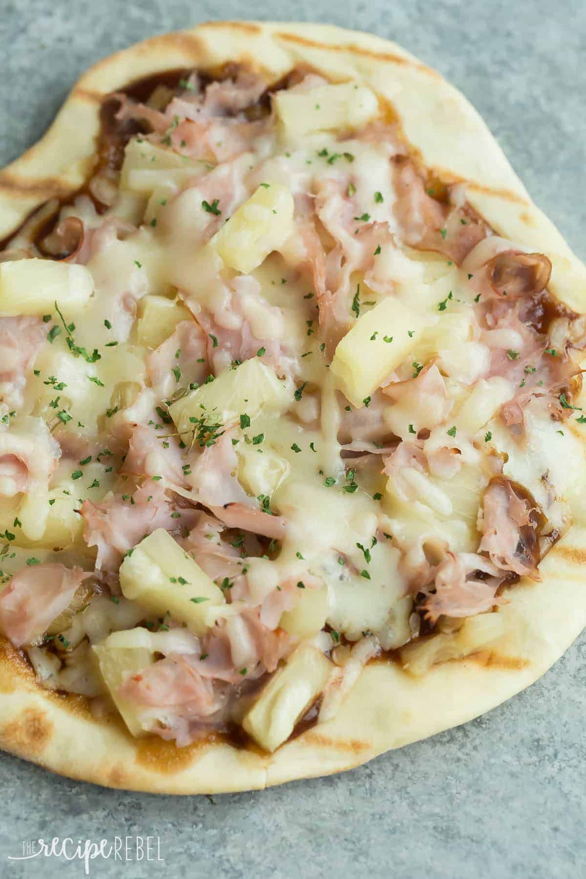 grilled bbq hawaiian pizza with ham pineapple and cheese on grey background