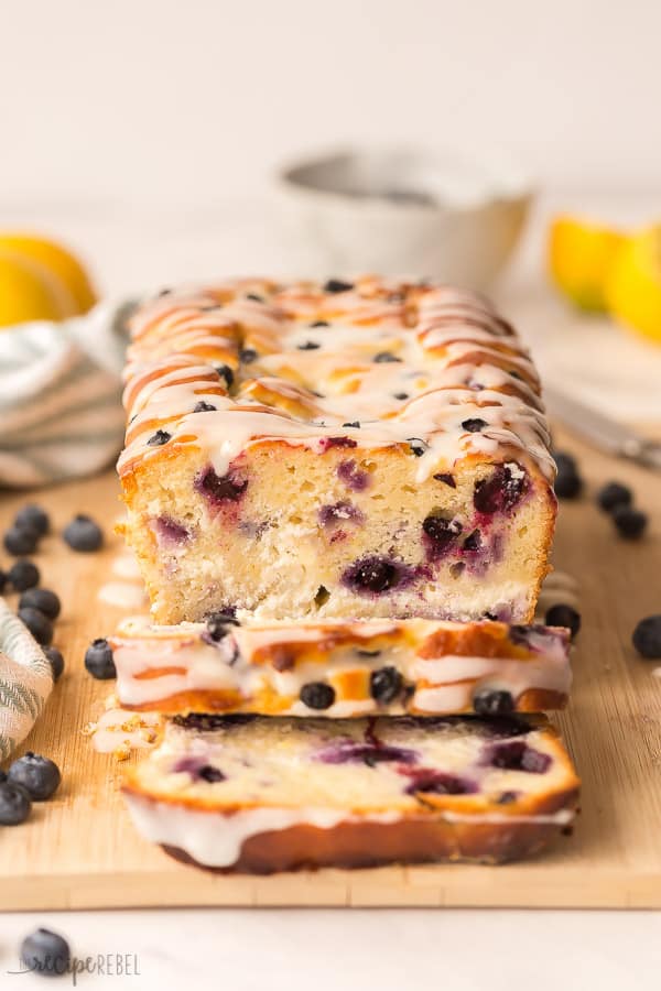 lemon bread with blueberries sliced and glazed with blue towel in background