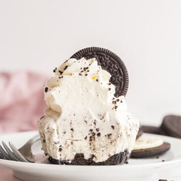 oreo ice cream cupcake with whipped cream and oreo and a bite taken