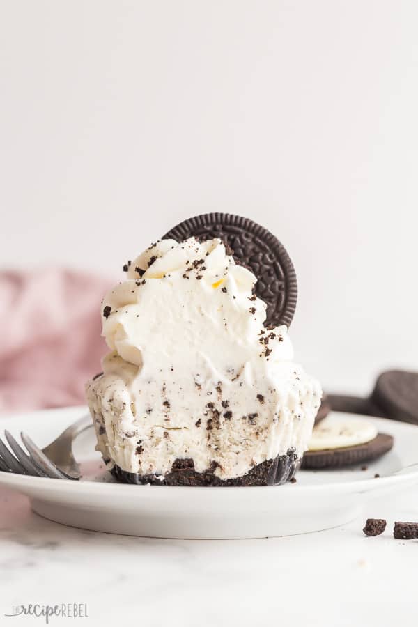 oreo ice cream cupcake with whipped cream and oreo and a bite taken