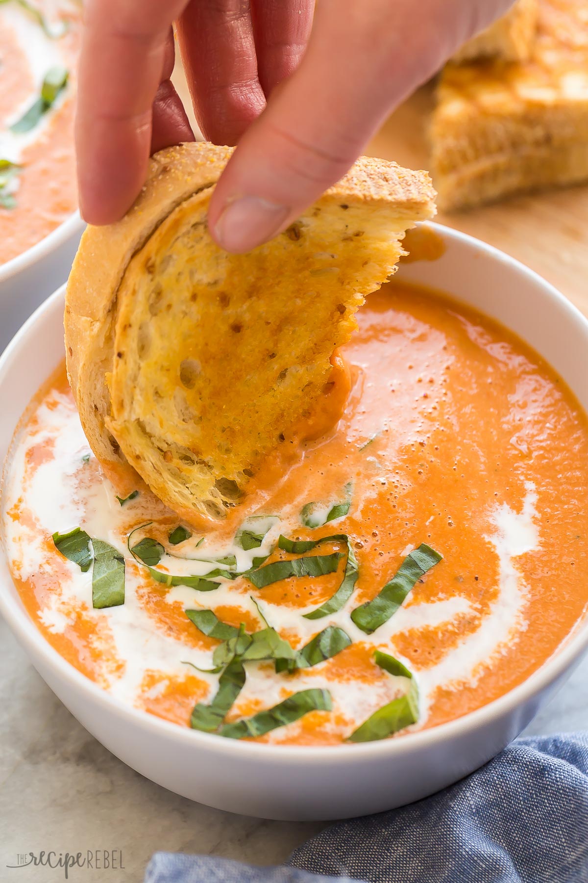 grilled cheese being dunked in tomato soup