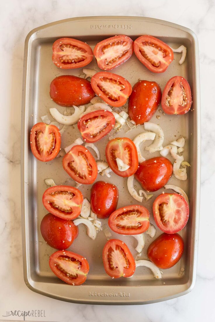fresh tomatoes and onions on a baking sheet