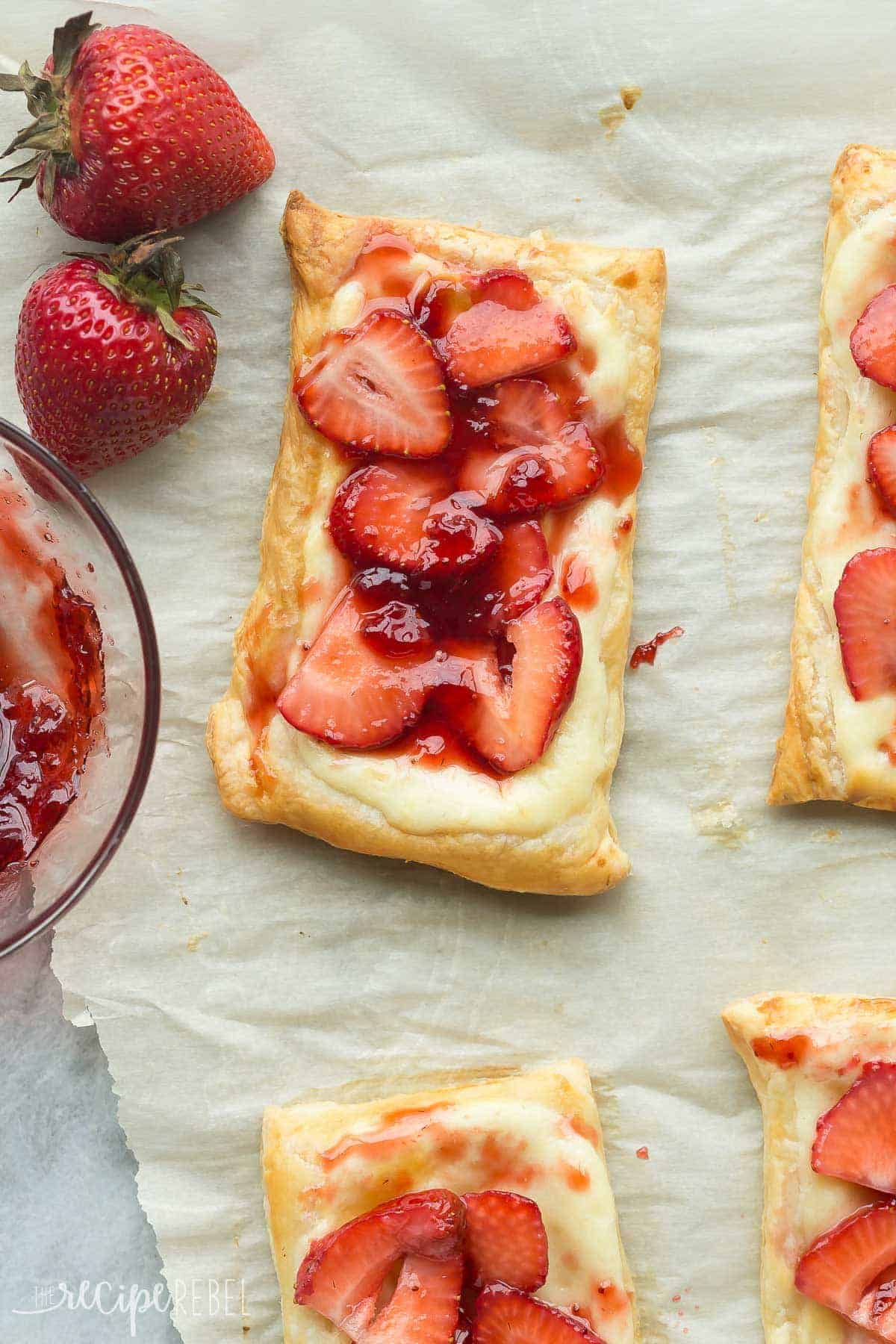 close up image of strawberry danish with fresh strawberries on the side