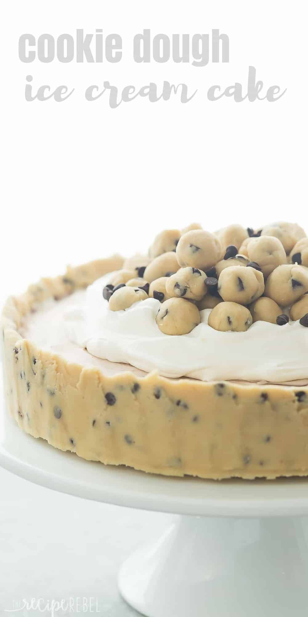 This Cookie Dough Ice Cream Cake is an easy, no bake dessert for a summer cookout or birthday party! Made on a cookie dough crust, filled with no churn ice cream and topped with chunks of cookie dough. Includes step by step recipe video tall close up image of cookie dough ice cream cake with cookie dough balls on top