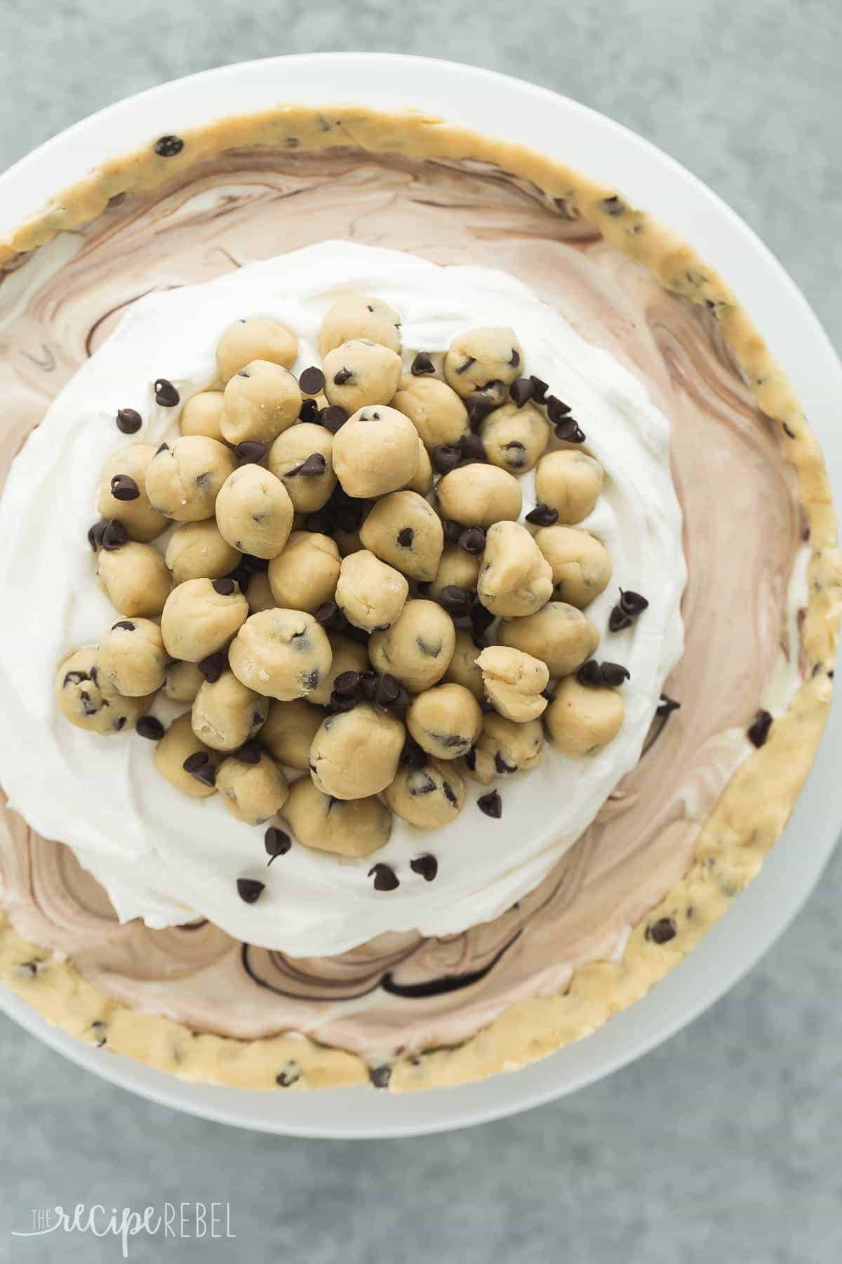 overhead image of cookie dough ice cream cake with whipped cream and cookie dough balls