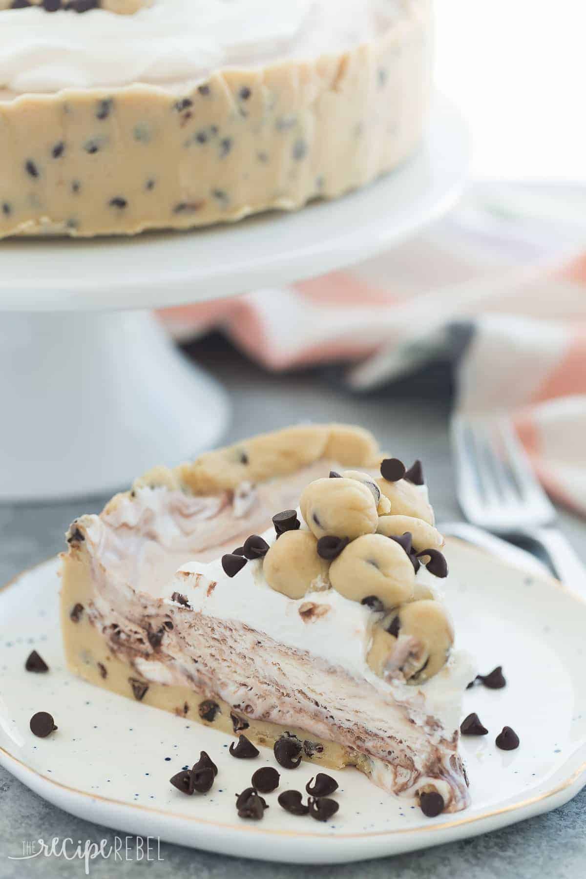 cookie dough ice cream cake slice on white plate with mini chocolate chips all around