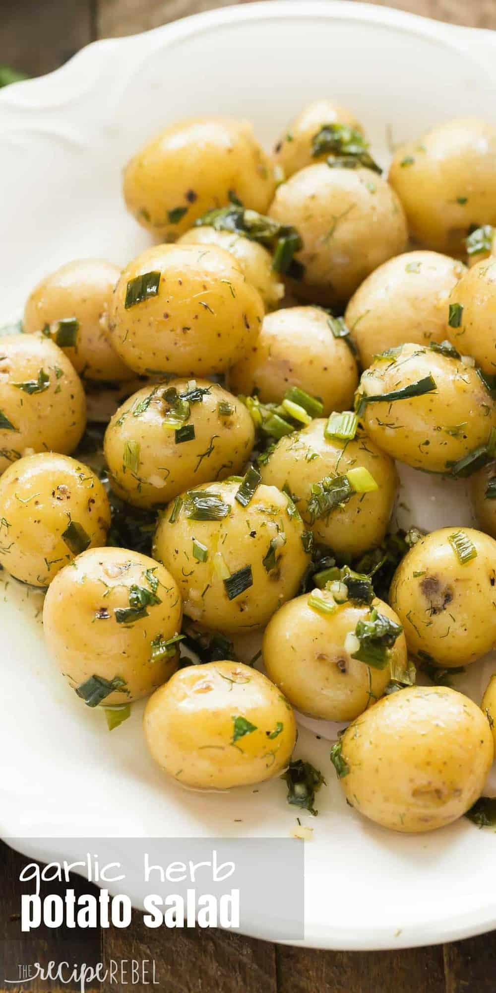 little potatoes in herb dressing on white plate