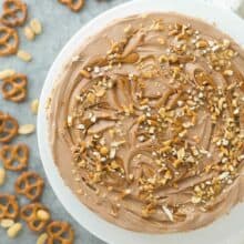 no bake chubby hubby cheesecake overhead image on white cake plate with peanuts and pretzels