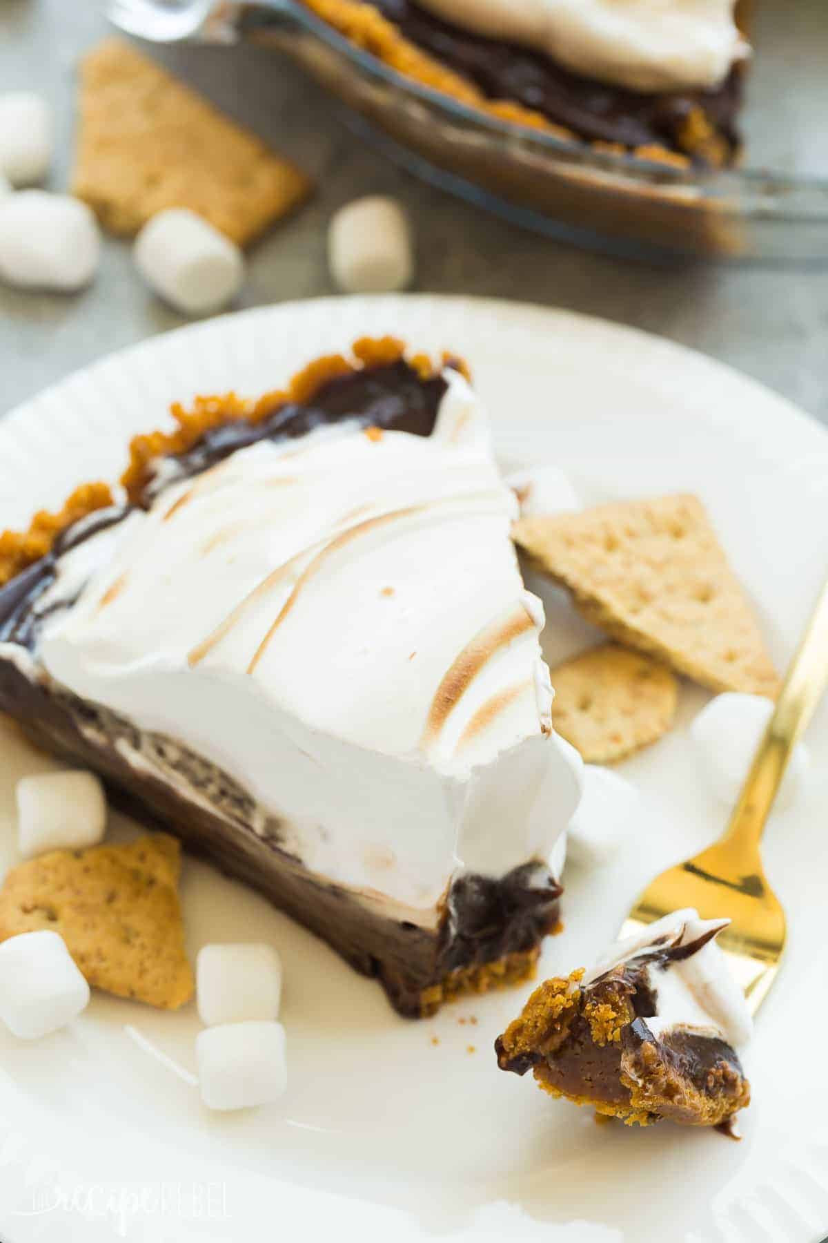 slice of no bake smores pie on white plate with bite on fork