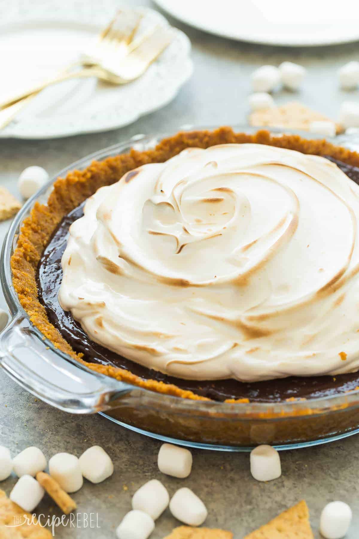 no bake smores pie in glass pie plate with graham crackers and mini marshmallows all around