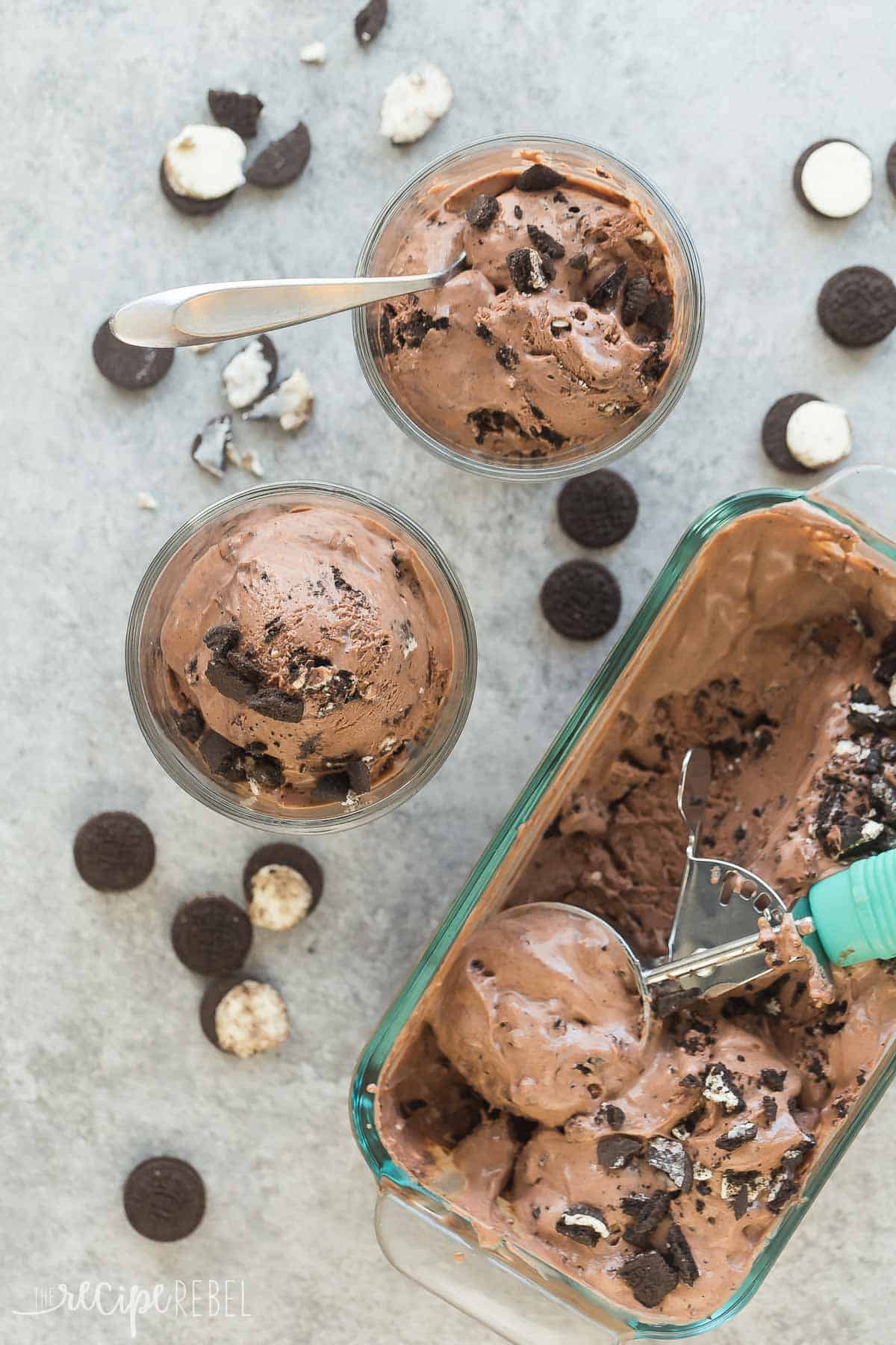 This No Churn Peanut Butter Oreo Ice Cream is SO easy -- just FIVE ingredients and a few minutes prep. It's a no bake dessert you can easily customize to your tastes! Includes step by step recipe video No churn peanut butter Oreo ice cream overhead in clear loaf pan with two small bowls of ice cream on the side.
