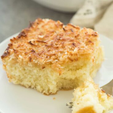 This Hot Milk Cake with Broiled Coconut Frosting -- also known as a Lazy Daisy Cake -- is a super moist vanilla cake covered in a crunchy, toasted coconut topping. It's one of my favorite cakes of all time! Includes a step by step recipe video. | easter | spring | Easter dessert | coconut dessert | baking | cooking | easy recipe