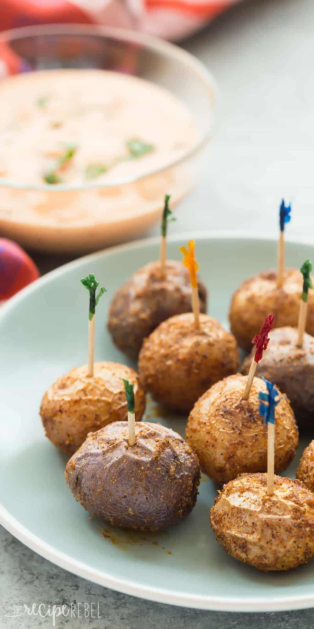 long image of nacho roasted potatoes on blue plate with toothpicks stuck in each