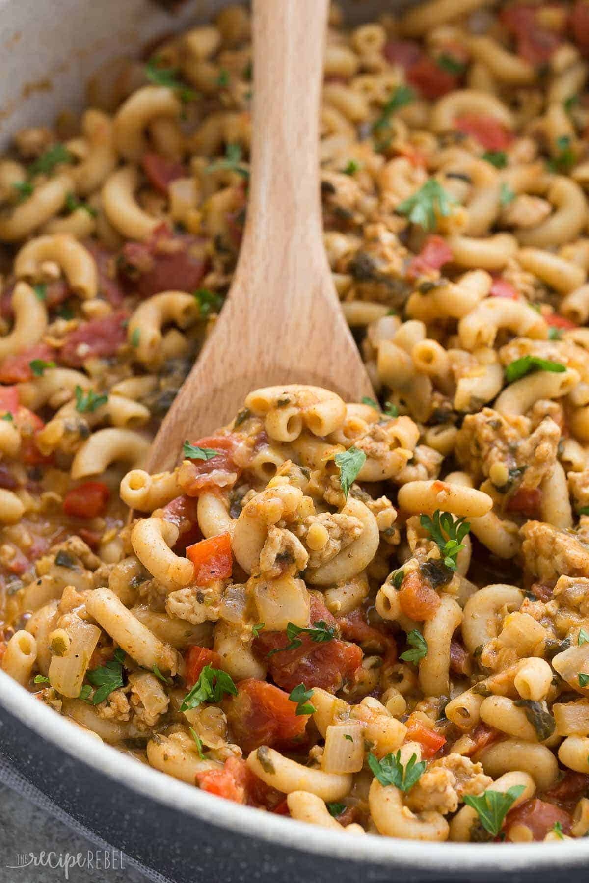 close up of turkey chili mac with lentils on wooden spoon