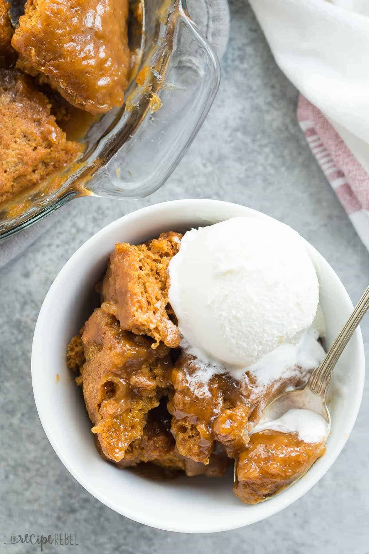 overhead image of bowl of pumpkin pudding cake with vanilla ice cream scoop