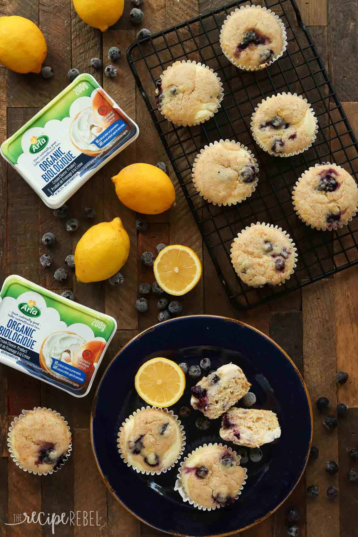 blueberry lemon muffins with cream cheese swirl overhead image on blue plate and black cooling rack