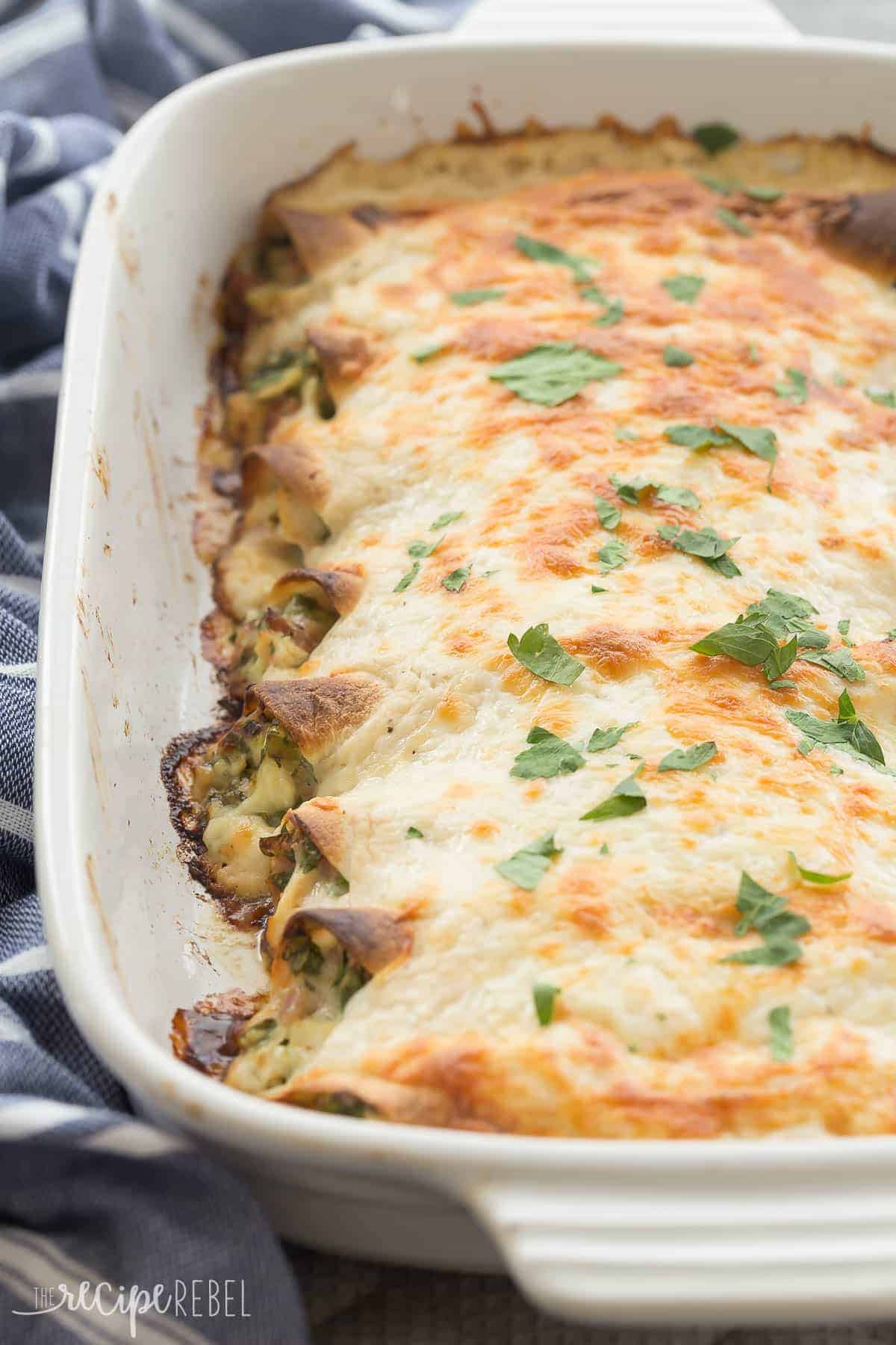 These Cordon Bleu Chicken Enchiladas are an easy, make ahead meal to keep on hand for busy weeknights! Loaded with chicken, ham, cheese and spinach, then smothered in Alfredo sauce and cheese, they are pure comfort food! Includes step by step recipe video. | easy recipe | make ahead dinner | freezer meal | freezer friendly | alfredo | chicken recipe