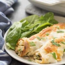 These Cordon Bleu Chicken Enchiladas are an easy, make ahead meal to keep on hand for busy weeknights! Loaded with chicken, ham, cheese and spinach, then smothered in Alfredo sauce and cheese, they are pure comfort food! Includes step by step recipe video. | easy recipe | make ahead dinner | freezer meal | freezer friendly | alfredo | chicken recipe