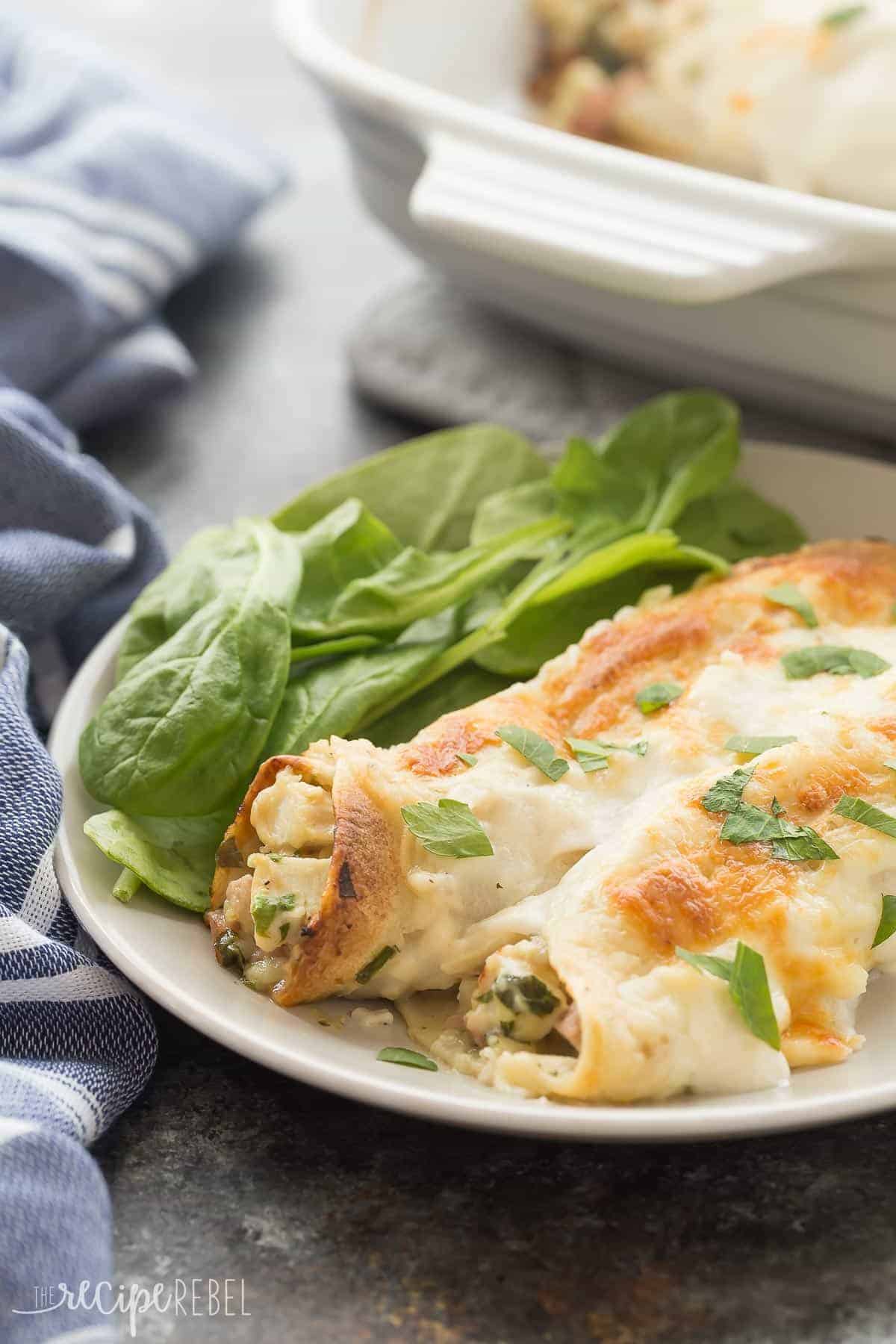 These Cordon Bleu Chicken Enchiladas are an easy, make ahead meal to keep on hand for busy weeknights! Loaded with chicken, ham, cheese and spinach, then smothered in Alfredo sauce and cheese, they are pure comfort food! Includes step by step recipe video. | easy recipe | make ahead dinner | freezer meal | freezer friendly | alfredo | chicken recipe