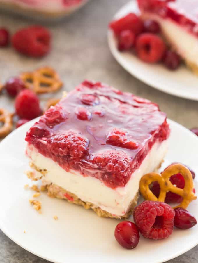 This Cranberry Raspberry Pretzel Salad Dessert is an easy holiday dessert salad that will be a big hit at Christmas or Thanksgiving! Made with cream cheese, fresh fruit and real fruit juice instead of Jello and includes a step by step recipe video. | christmas dessert recipe | holiday dessert | cranberry dessert | raspberry dessert | Thanksgiving recipe | no bake dessert