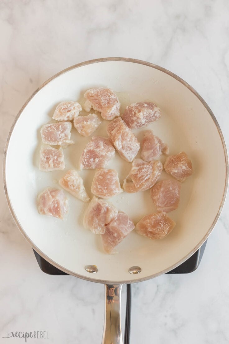 chicken coated in corn starch in white frying pan