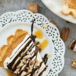This Turtle Pumpkin Pie is made on a flaky pie crust, topped with pecans, caramel and a no bake pumpkin pie filling! Make it in a graham cracker or Oreo crust for a completely no bake Thanksgiving dessert! Includes step by step recipe video. | pumpkin dessert | Thanksgiving dessert | caramel | chocolate | pecans | no bake dessert