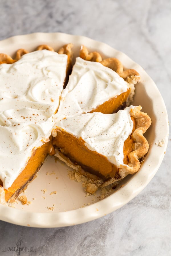 This Turtle Pumpkin Pie is made on a flaky pie crust, topped with pecans, caramel and a no bake pumpkin pie filling! Make it in a graham cracker or Oreo crust for a completely no bake Thanksgiving dessert! #pie #pumpkin #thanksgiving #dessert #pumpkinpie two slices of turtle pumpkin pie cut in pan