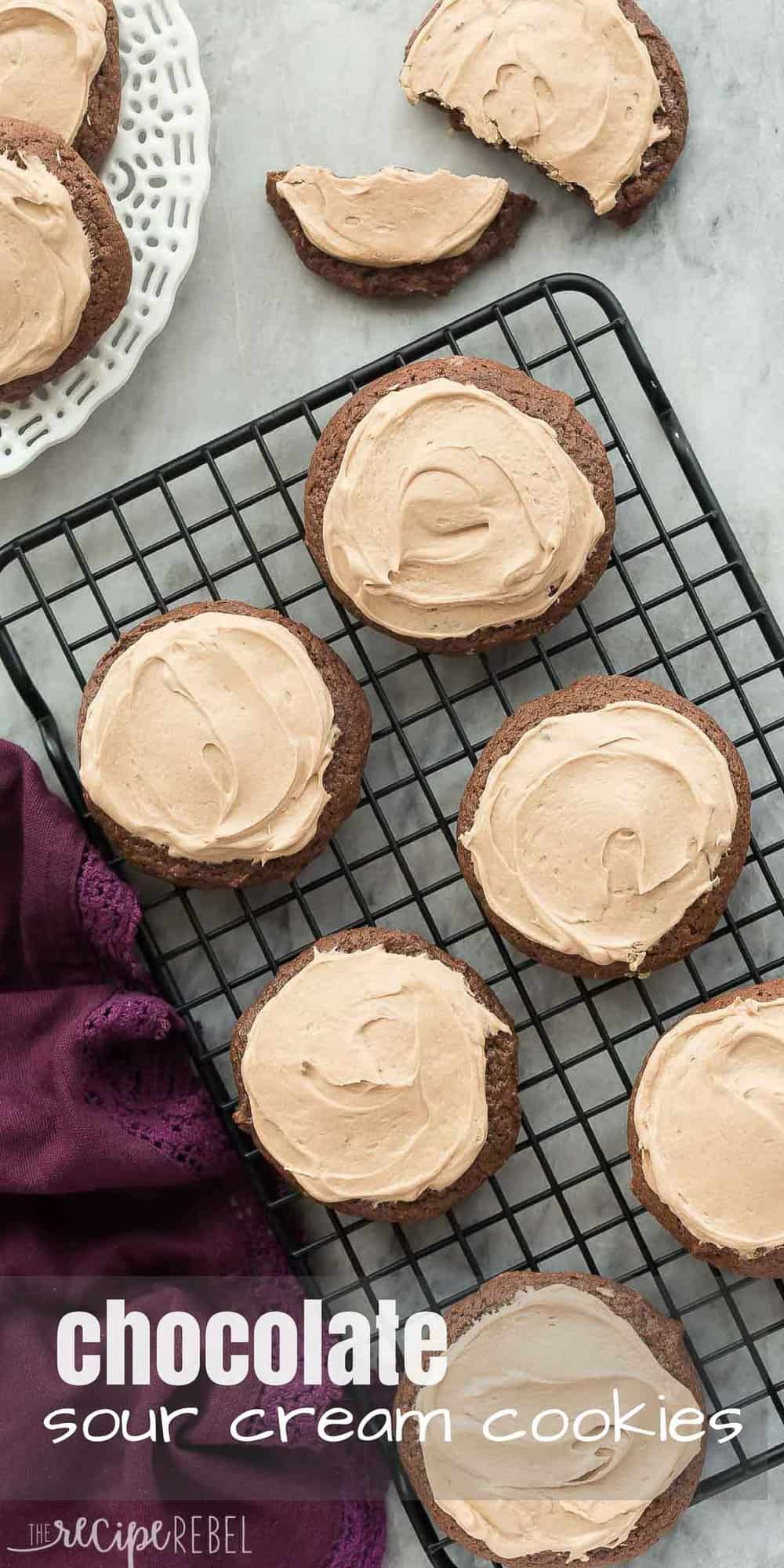 These Chocolate Sour Cream Sugar Cookies are super soft and smothered in chocolate cream cheese frosting -- it's everything a chocolate cookie should be! Includes a step by step recipe video. long overhead image of chocolate sour cream cookies with frosting on black cooling rack
