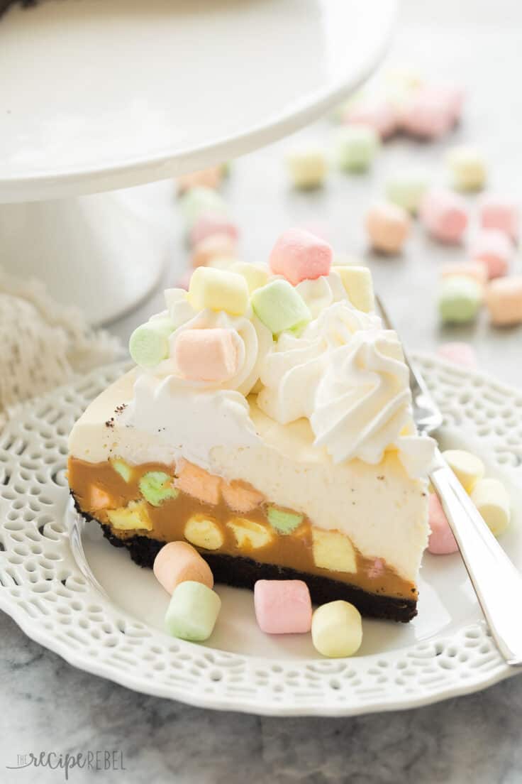 no bake peanut butter marshmallow cheesecake on white plate with multi colored marshmallows all around