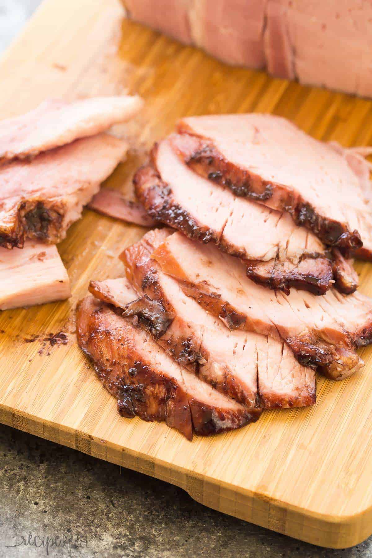 slices of ham on cutting board with cherry glaze