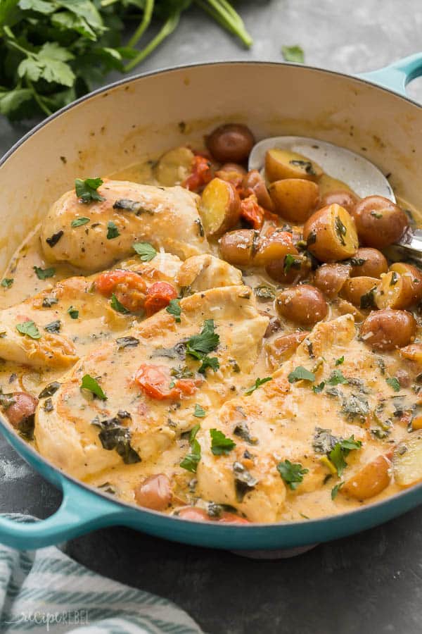 tuscan chicken skillet close up with little potatoes and metal scoop