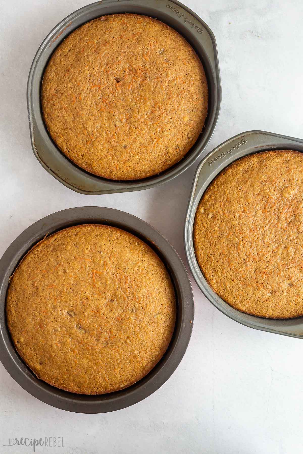 three 8 inch carrot cake layers in round pans fully baked