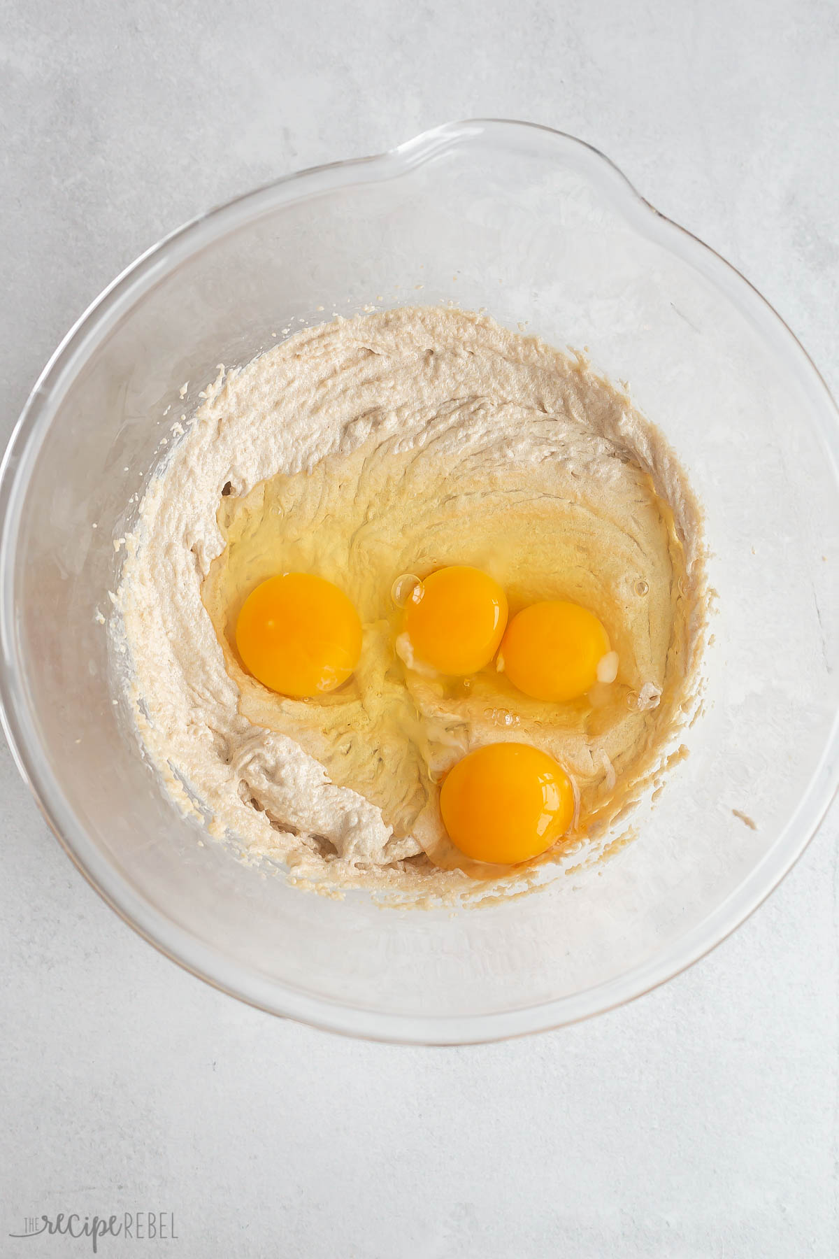 eggs added to butter and sugar in glass bowl