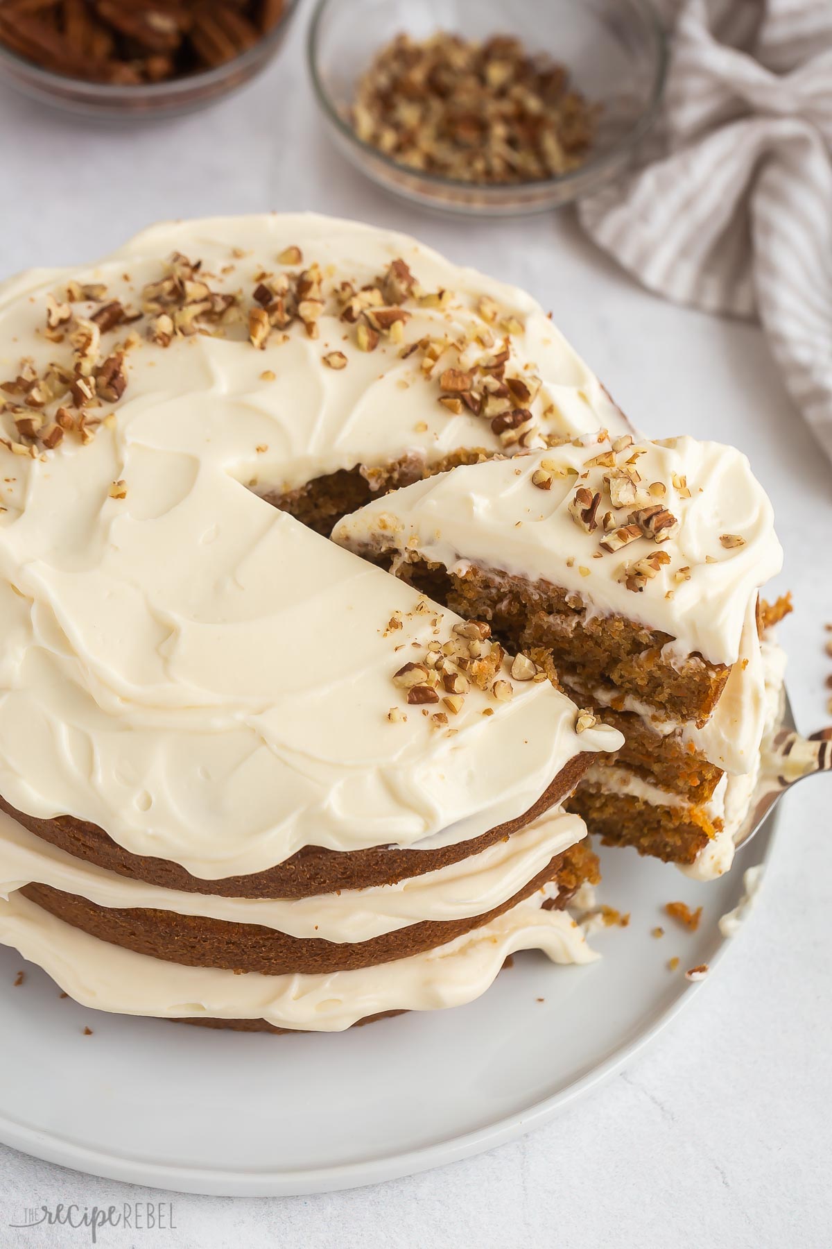 piece of carrot cake being pulled out of whole carrot cake